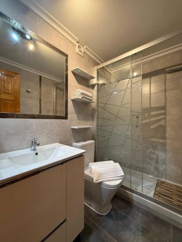 Un baño con inodoro, lavabo y ducha. en Casa Mediterránea Gran Alacant, en Gran Alacant