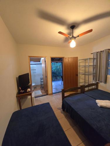 a bedroom with two beds and a ceiling fan at Pousada Rancho Minêro in Delfinópolis