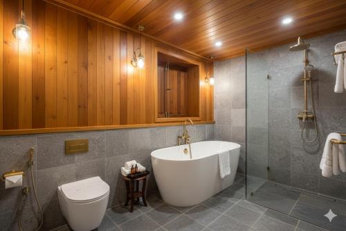 Suchanan Resort Rayong في بان تشانغ: حمام مع حوض استحمام ومرحاض ودش