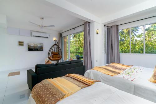 a bedroom with two beds and a window at La Sky Stay in Ukulhas