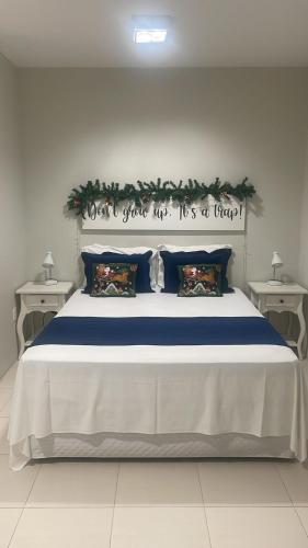a bedroom with a large bed with a sign on it at Fish Inn Hotel in Barra Velha