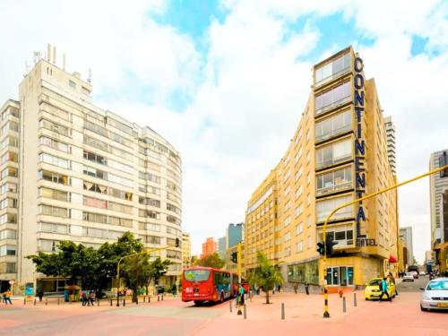 ボゴタにあるHotel Continental ByHoursの建物のある街路赤バス