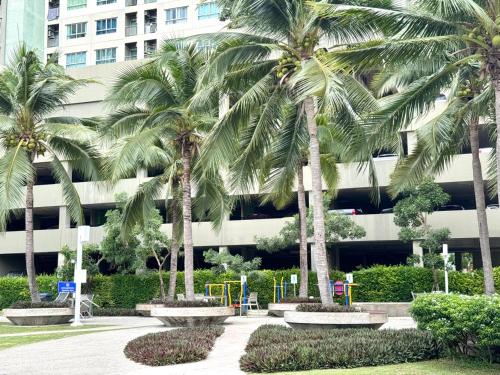 a group of palm trees in front of a building at Lumpini Ville Naklua Select Resort Pool condo in North Pattaya