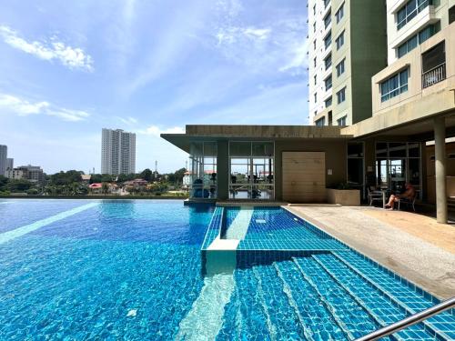 a large swimming pool in front of a building at Lumpini Ville Naklua Select Resort Pool condo in North Pattaya