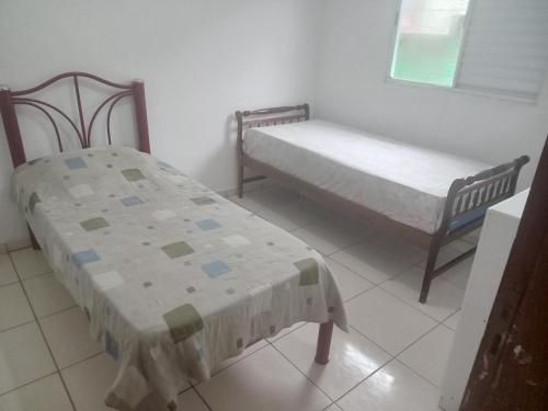 twee bedden in een kamer met een raam bij Casa independente e aconchegante in Poços de Caldas