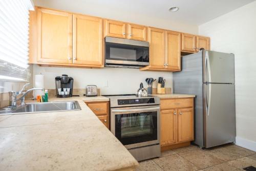 a kitchen with wooden cabinets and a stainless steel refrigerator at Sea Breeze -Great Location! in Key West