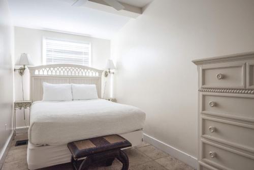 a white bedroom with a bed and a dresser at Sea Breeze -Great Location! in Key West