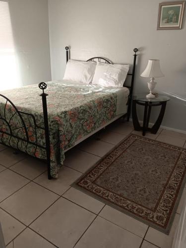 a bedroom with a bed and a table with a lamp at GpL 3115 A Family Get Away in Fort Myers