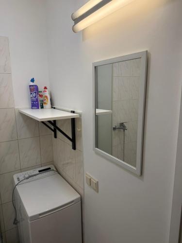 a small bathroom with a mirror and a washing machine at Compact & Smart Mini Studio, self check-in in Rīga