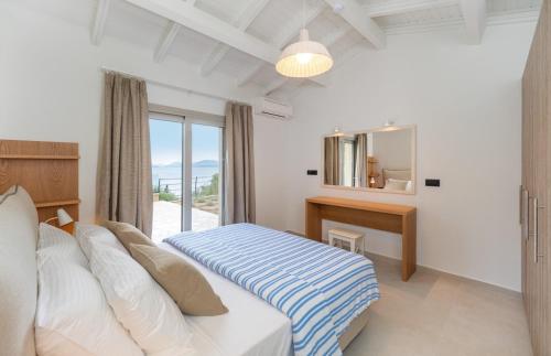 um quarto com uma cama, uma escrivaninha e uma janela em Simpson Secret Corfu em Nisakion