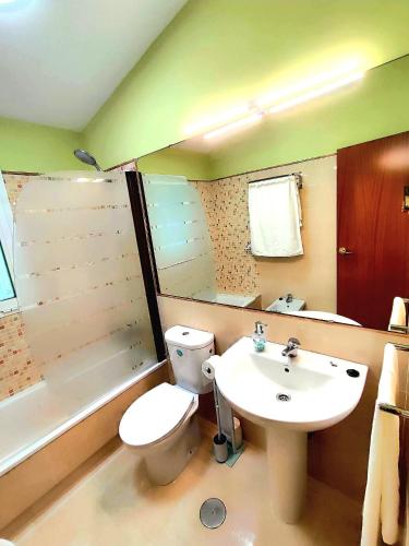 a bathroom with a white toilet and a sink at Adosado kintsuji in Sanlúcar de Barrameda
