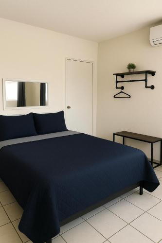 ein Schlafzimmer mit einem blauen Bett und einem Tisch in der Unterkunft Hotel Esperanza in Esperanza