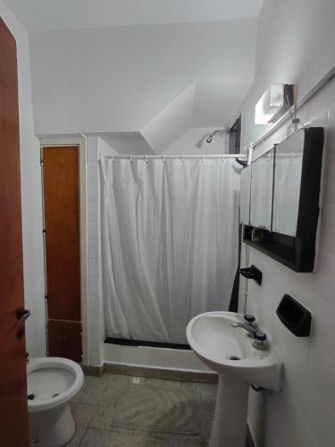 a bathroom with a white shower curtain and a sink at Nami in Necochea
