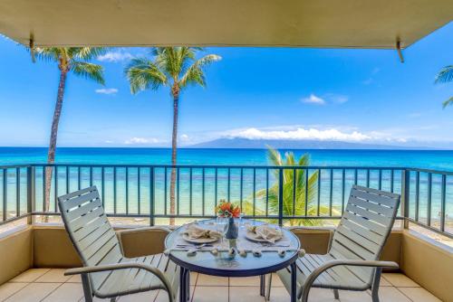 Una mesa en un balcón con vista al mar. en Paki Maui 302A, en Honokowai