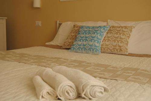 a bed with two towels laying on top of it at Coro & Bentu in Alghero