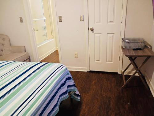 a bedroom with a bed and a table and a door at Fletcher Street Hideaway Room 8 with Cozy Vibes in Atlanta
