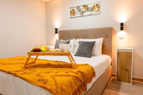 a bed with a tray of fruit on top of it at LaurissilvaLodge in Senhora do Rosário