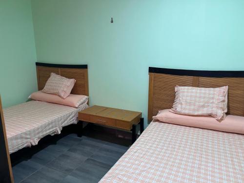 two beds in a small room with pink sheets at Ewa in Hurghada