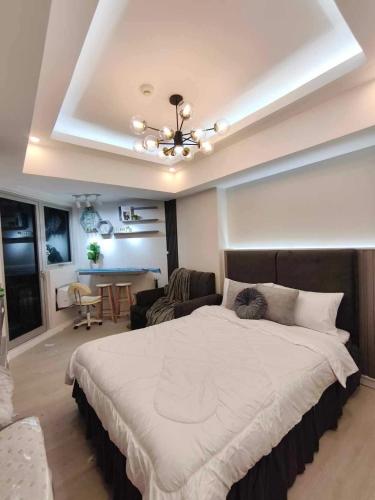 een slaapkamer met een groot bed en een woonkamer bij Z Crib - Azure North in San Fernando