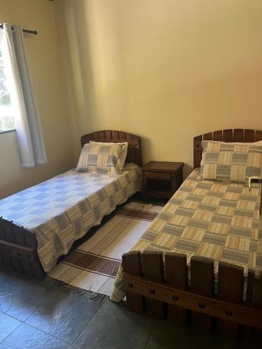 two beds sitting next to each other in a bedroom at Sítio com rio e muito verde! in Rio Bonito