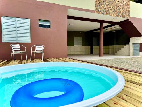 a large blue swimming pool in front of a house at Casa Completa com Piscina Churrasqueira Wi-Fi a 300m da Praia Acomoda 10 Pessoas, 3 Quartos com Ar-Condicionado in Penha