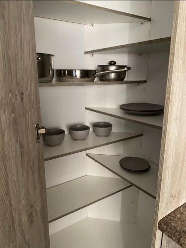 a kitchen with shelves with pots and pans on them at Vaal Home near Aquadome in Vanderbijlpark