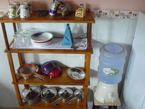 una mensola in legno con piatti e utensili di Chalé Borboletas Centro Pipa RN a Pipa