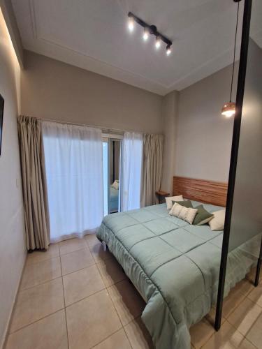 Monoambiente de diseño في كورينتس: غرفة نوم بها سرير ونافذة كبيرة