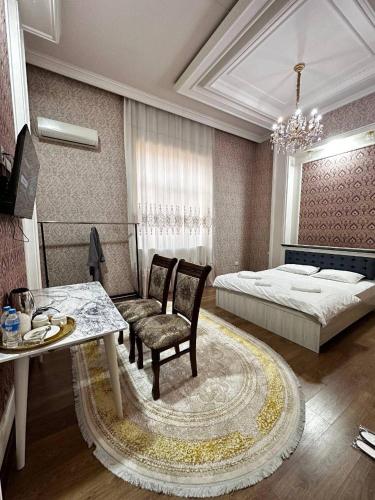 a bedroom with a bed and a table and chairs at Cosmos Hotel in Yakkasaray