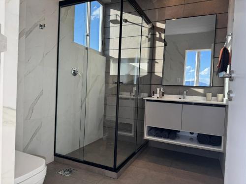 une salle de bain avec une douche en verre et un lavabo dans l'établissement Luxury and Relax at 8432 ft, à Cochabamba
