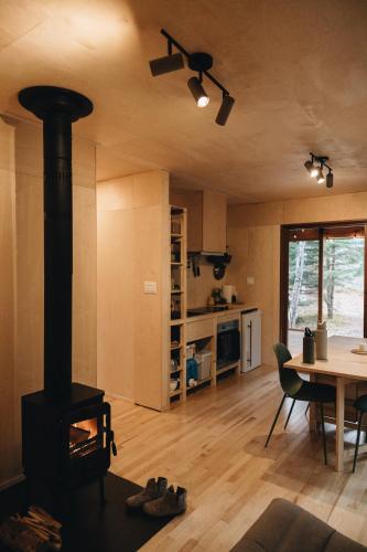 a living room with a wood stove and a table at Micro-cabine, Méandre, La Tuque in La Tuque