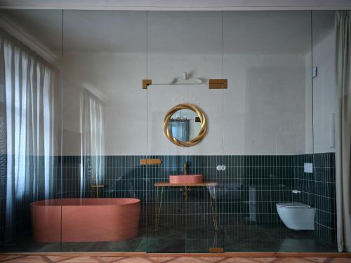 donebe hotel & wellness Kutná Hora في كوتنا هورا: حمام مزود بحوض استحمام ومغسلة ومرآة