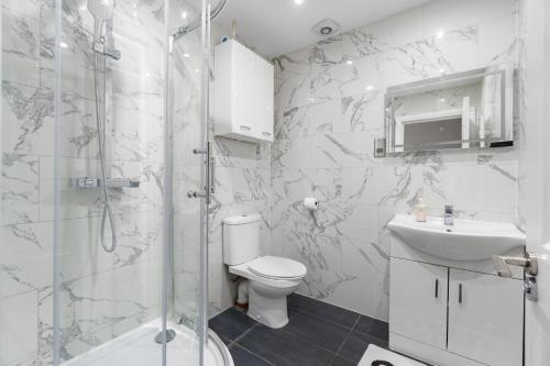a bathroom with a shower and a toilet and a sink at 2 Bedroom house,BrownhillRd SE6 in London