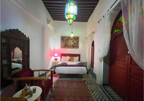a bedroom with a bed and a couch and a table at Riad Dar Iman in Fès