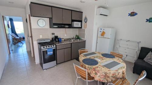 a kitchen and dining room with a table and a refrigerator at Lagoon Sunset view entire apartment in Cancún