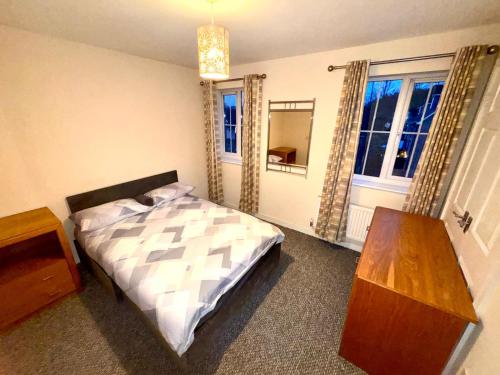 a bedroom with a bed and a table and a window at Sorrell Gardens Guest House in Newcastle under Lyme
