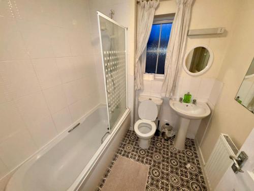 Sorrell Gardens Guest House في نيوكاسل أندر ليم: حمام مع مرحاض ومغسلة