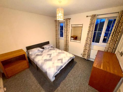 Sorrell Gardens Guest House في نيوكاسل أندر ليم: غرفة نوم بسرير وطاولة ونافذة