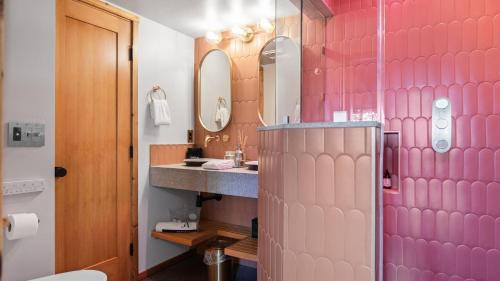 a pink bathroom with a sink and a mirror at 5BDR Hot Tub Deck Firepit Mins to Village Lake The Hilltop by AvantStay in North Shore