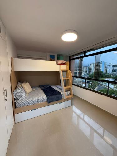 um quarto com um beliche e uma grande janela em Oceanfront Playa Grande 10 min Airport Aeropuerto em Maiquetía