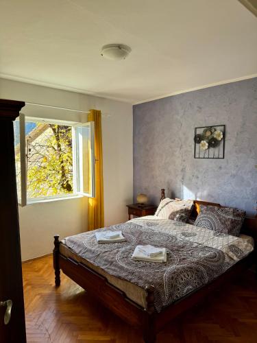 a bedroom with a bed with two towels on it at Red House Apartment in Kotor
