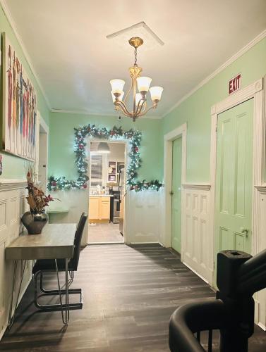 a dining room with green walls and a table and a chandelier at Big Mama's House in Paterson