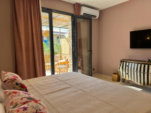 Casaromatica في Pigna: غرفة نوم بها سرير وباب زجاجي منزلق