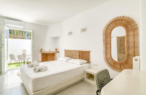 een witte slaapkamer met een bed en een spiegel bij Casa Lina large central apartment, beach access in Kampos Paros