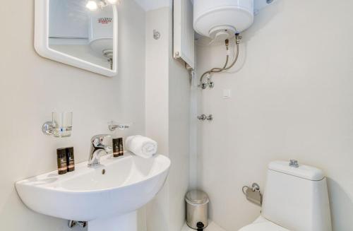 een witte badkamer met een wastafel en een toilet bij Casa Lina large central apartment, beach access in Kampos Paros