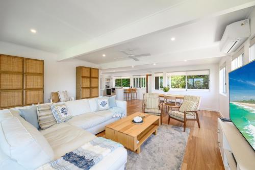 a living room with a white couch and a table at Noosa Escape 2BR Ocean Views, Walk to Beach in Noosa Heads