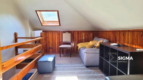 um quarto no sótão com um sofá e uma cama em Amplia Casa Familiar en Condominio Privado em Pucón