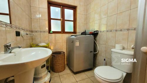 uma casa de banho com um WC, um lavatório e um frigorífico em Amplia Casa Familiar en Condominio Privado em Pucón