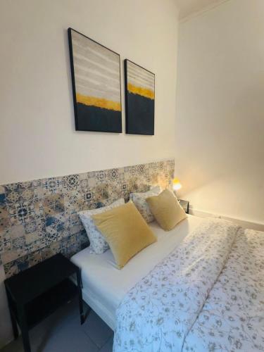 a bedroom with a bed with two pictures on the wall at Frank's House & Happy BELEM in Lisbon