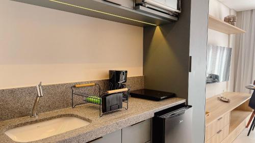 a kitchen counter with a sink and a microwave at Setai Aquamaris Luxo - By Almare in Tambaú